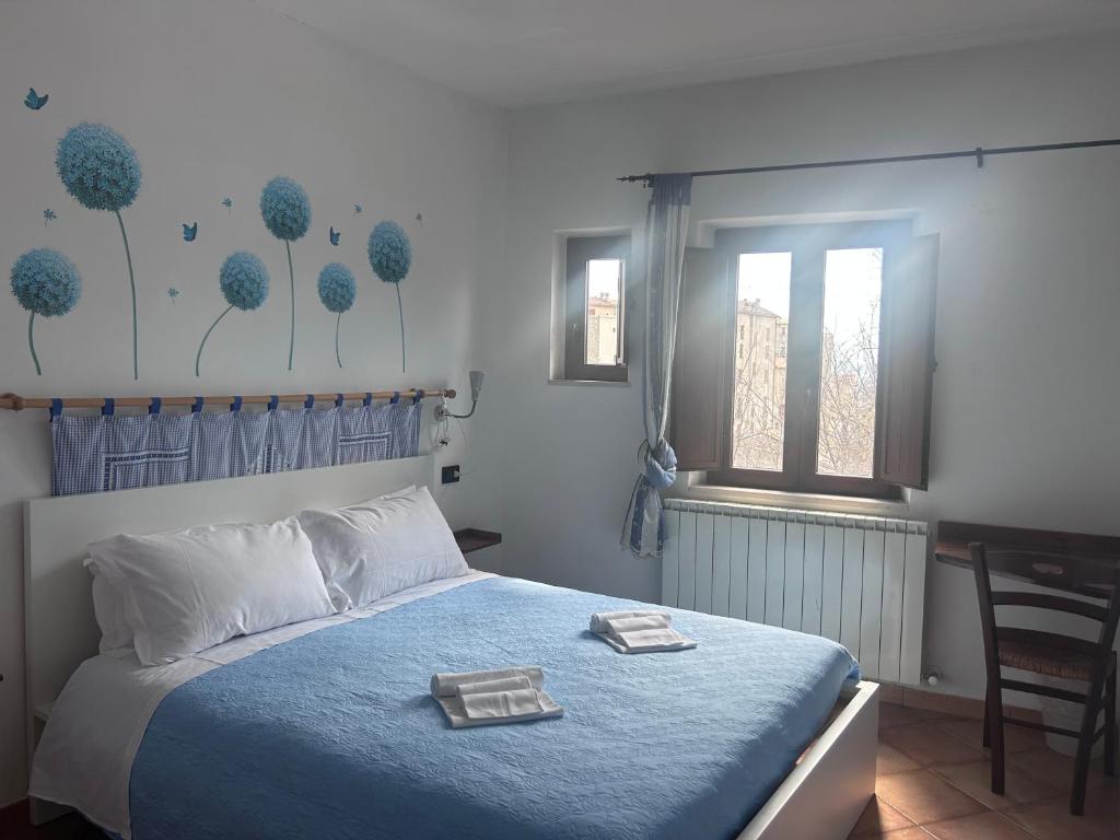 Camera matrimoniale azzurra con vista sul borgo e decorazione murale a soffioni blu — Affittacamere Mappavel's, Castel del Monte